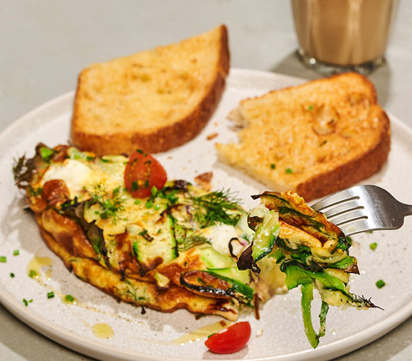 <p>A delightful, pan-fried of omelette elevated with ribboned zucchini, spinach, feta, red onion and cheese. Served with toasted sourdough, fresh cherry tomato, dill and chives for a burst of fresh flavours.<br/>3281kJ</p>